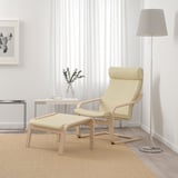 Modern living room with beige POÄNG armchair & ottoman. Soft leather, curved wood frame. Floor lamp & side table. Neutral decor.