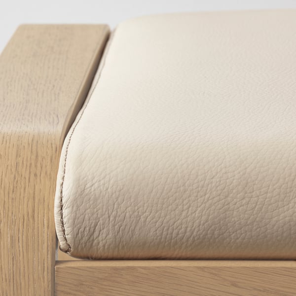 Close-up of a cushioned chair made with quality leather and wood, highlighting smooth texture and craftsmanship.