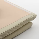 Close-up of a high-quality, beige POÄNG cushion with leather and polyester fabric, showcasing its durable stitching and comfortable appearance.
