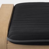 Covered stool, dark cloth, horizontal lines, wooden edge.