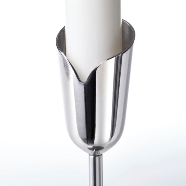 Elegant stainless steel candle holder with sleek, petal-like design. Holds white candle securely, reflecting light gracefully.