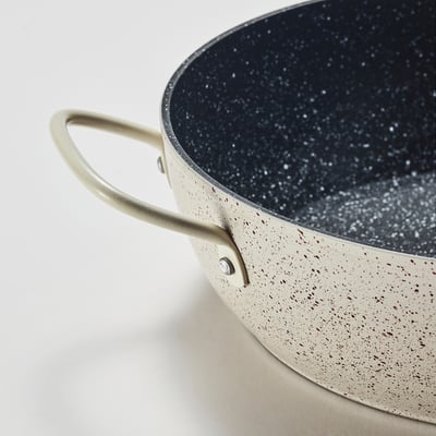 Modern non-stick cookware with speckled interior, robust tan handle, ideal for even cooking.