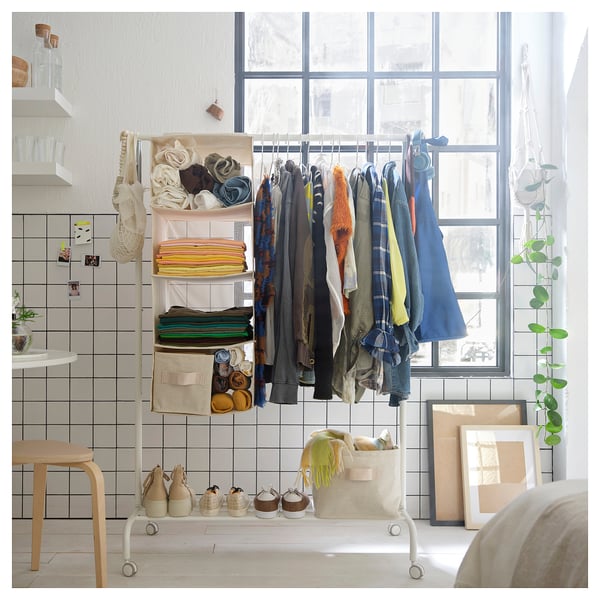 Organized closet with PURRPINGLA hanging storage shelves holding folded clothes and accessories. White with multiple compartments.