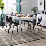 Modern dining room with brown/grey tartan wool rug, white table & black chairs, teal curtains, & decorative items.