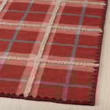 Red plaid rug, hand-woven with quality wool and cotton. Intricate stitching and varied pile heights for a luxurious feel.