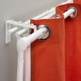 White curtain rod system holding orange curtains, showcasing flexibility with multiple rod holders and adjustable length.