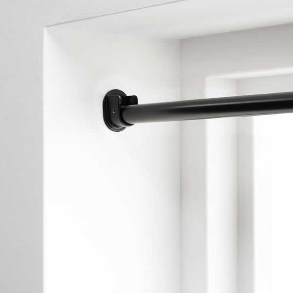 Black curtain rod bracket mounted on white wall, designed for secure and adjustable curtain hanging.