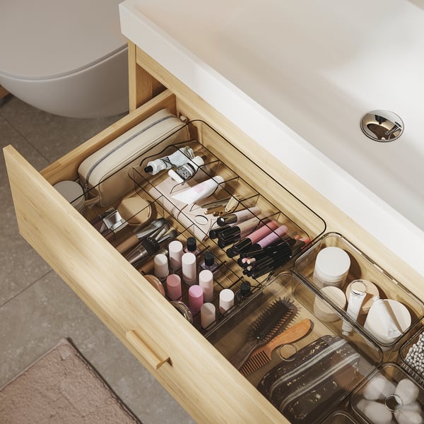 Organised bathroom drawer with makeup, accessories, and wellness tools.