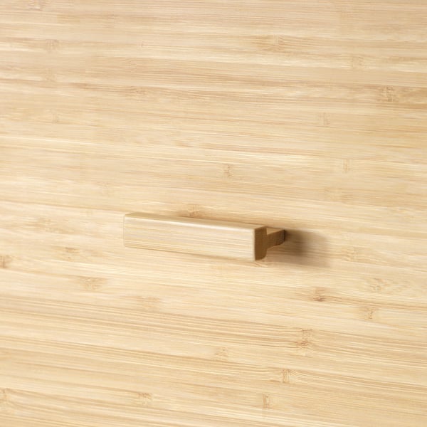 Close-up of sleek bamboo handle on light wood, showcasing natural texture and craftsmanship.