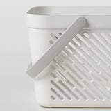 White plastic storage basket with holes, foldable handle for easy carrying, perfect for bathroom or kitchen.