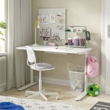 A kid’s white desk setup with RELATERA underframe, featuring a chair, pegboard, and accessories.