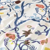 Bright, vibrant floral print fabric with intricate blue branches and colorful flowers, showcasing high-quality, detailed design.