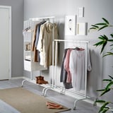 Adjustable clothes rack with hanging garments and shelves, showing storage flexibility.