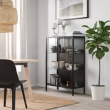 Modern living room with RUDSTA cabinet, plant, dining area, and minimalist decor.