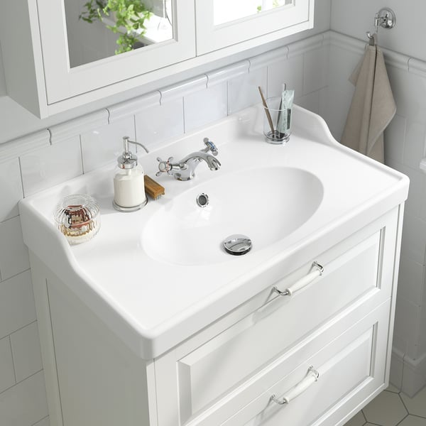 A pristine bathroom sink with chrome faucet and soap dispenser, equipped with water-saving aerator.