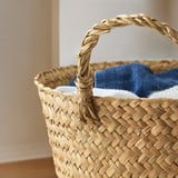 Woven basket with braided handle, lined with blue fabric.
