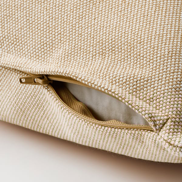Beige cushion with textured fabric, open zipper revealing inner lining.