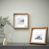 Two wall photos: art & beach, plant near.