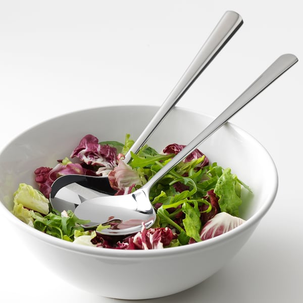A bowl of mixed greens with salad servers; stainless steel utensils designed for durability and easy cleaning.