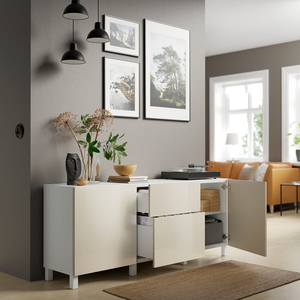 Modern living room with white cabinet, open doors, pendant lights, and orange couches by a window.