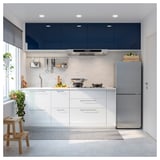 Modern kitchen with white SIBBARP cabinets, gray fridge, marble backsplash, stainless hood. Minimalist design with sleek lines and clean surfaces.