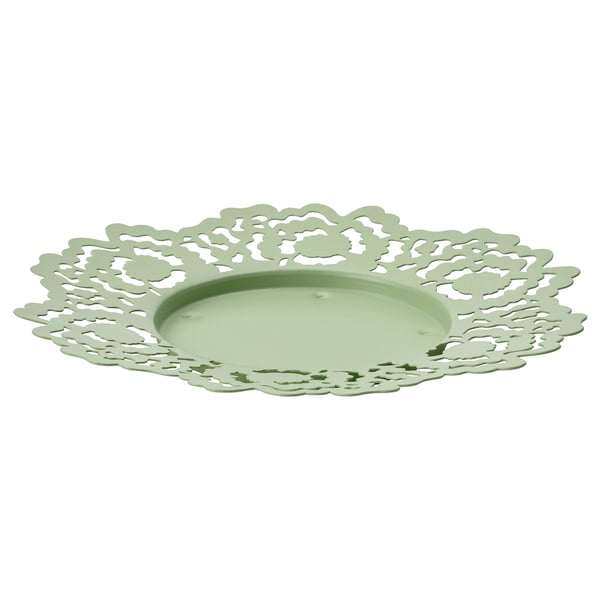 A round green metal candle dish with a delicate floral cutout design.