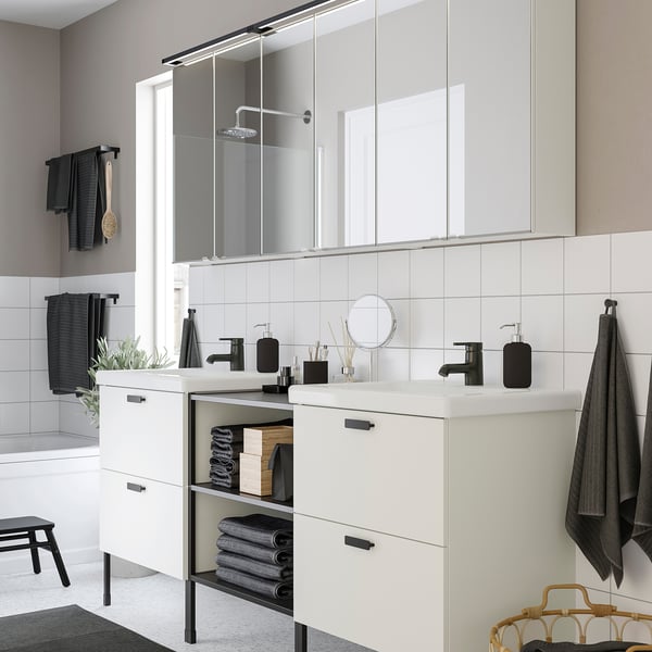 Modern bathroom: white cabinet, black fixtures, mirror, led lighting.