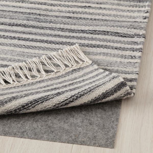 Striped gray wool rug with fringes, perfect for warm floors.