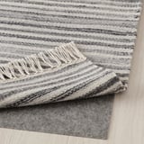 Striped gray wool rug with fringes, perfect for warm floors.