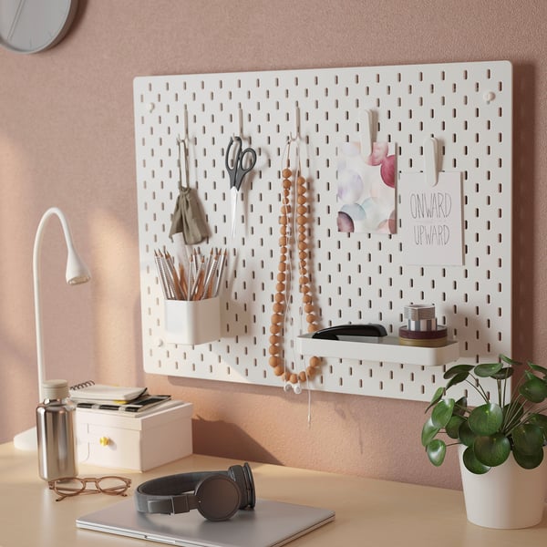 White SKÅDIS pegboard organizes office supplies, decorations, and hangs items efficiently.