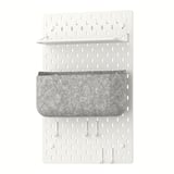 This image shows a white SKÅDIS wall organizer with a shelf and grey fabric pocket.