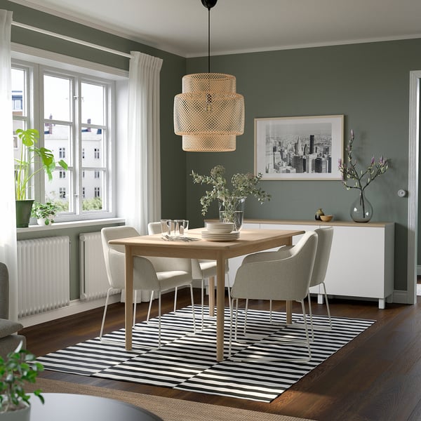 Modern green dining set with table, chairs, light, and rug.