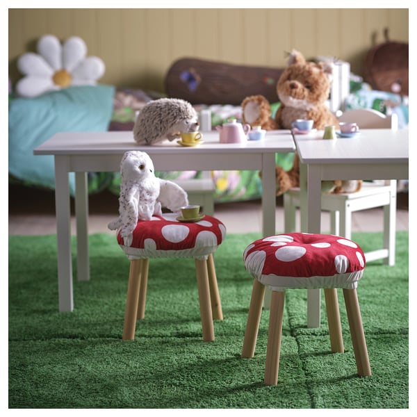 Polka-dot cushions on stools with stuffed animals and teacups, perfect for kids play in whimsical forest setting.