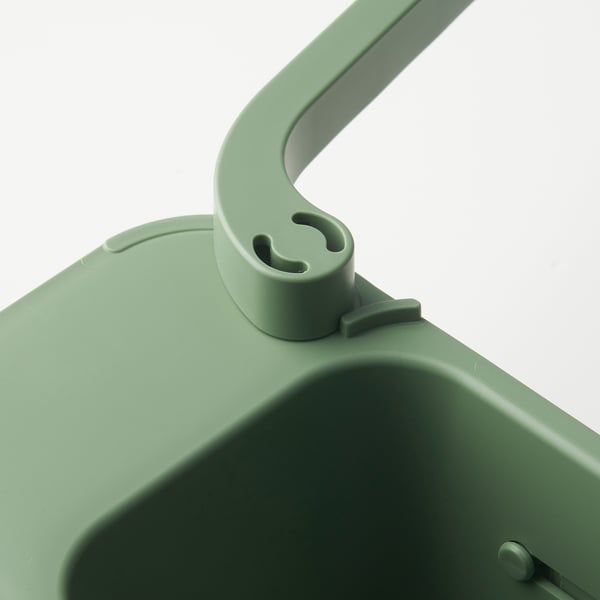 Close-up of SKOLÄST green sink organizers sturdy handle and base with drainage holes.