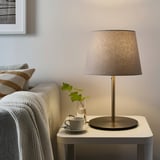 SKOTTORP lampshade, neutral, made of pet & linen on small round table.
