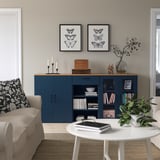 Modern living room with SKRUVBY blue sideboard, sofa, and coffee table, adorned with butterfly prints.