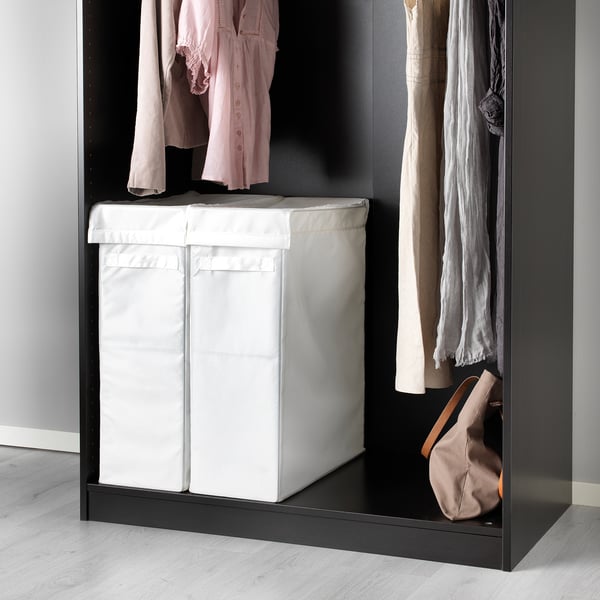 Black wardrobe with white laundry bag for clothes storage.