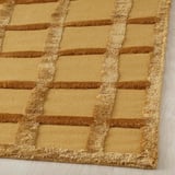 Close-up of a high-quality, handwoven rug with a grid pattern, showcasing its texture and intricate design.