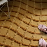 Handwoven wool rug with 3d wave pattern and pink slippers on it.