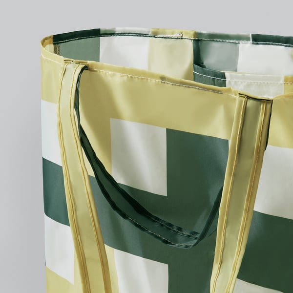 Foldable tote bag with green and white stripes; sturdy handles and neat stitching.