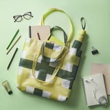 Yellow SKYNKE bag, striped, folds, holds essentials, recyclable.