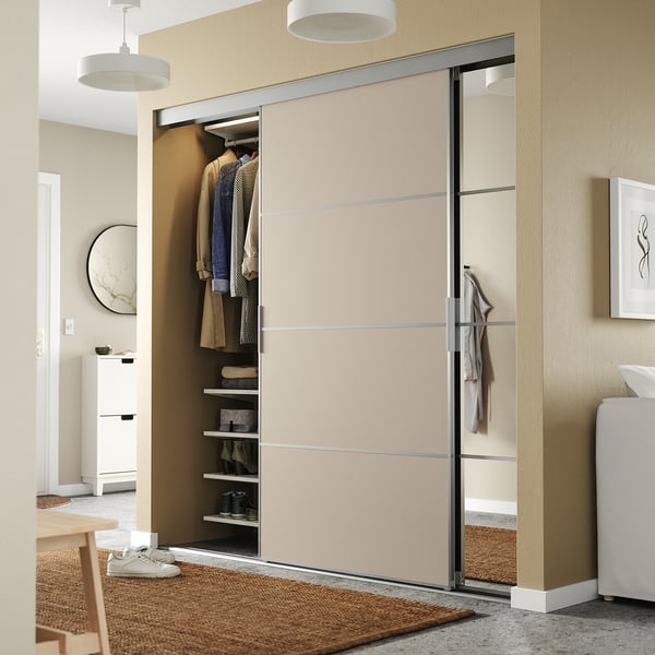 Modern closet with SKYTTA sliding glass door, clothes, shelves, and round lights in cozy room.