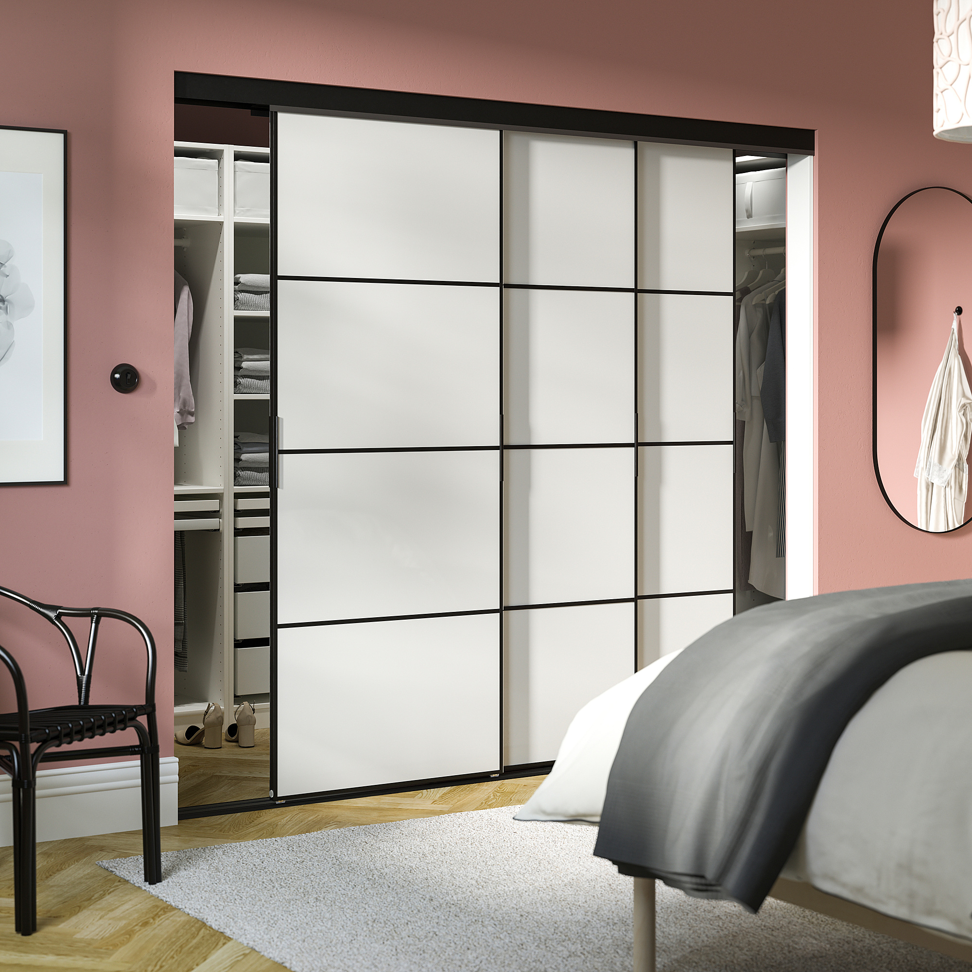 Modern bedroom with SKYTTA sliding closet doors, pink walls, and minimalist decor.