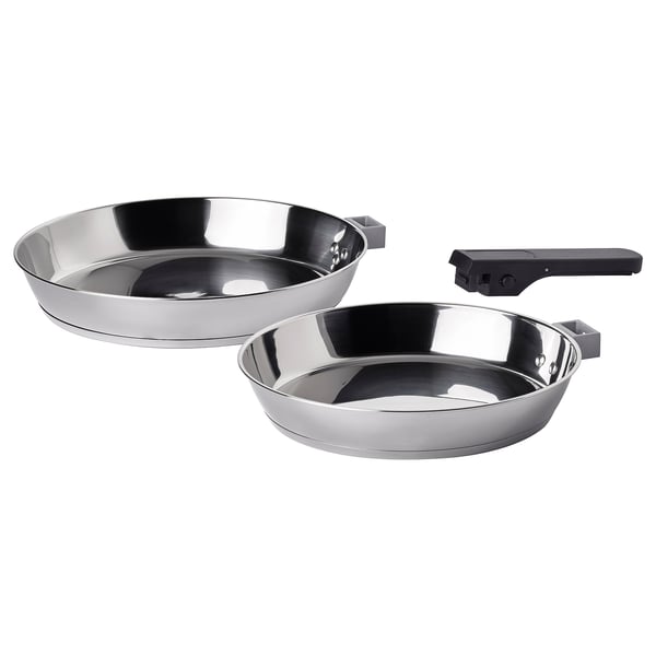 Two shiny silver SLÄTROCKA frying pans, one larger, one smaller, with detachable black handles, arranged neatly side by side.