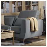 Modern grey SLATORP sofa with wooden legs, cozy blankets, and wine glass on a coffee table.