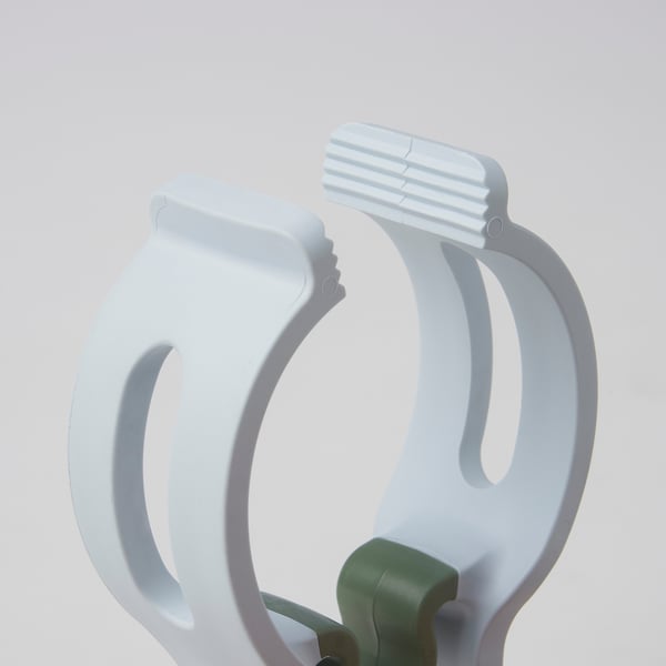 Two white clothes pegs, one green, robust and ready for heavy laundry, set against a light gray background.