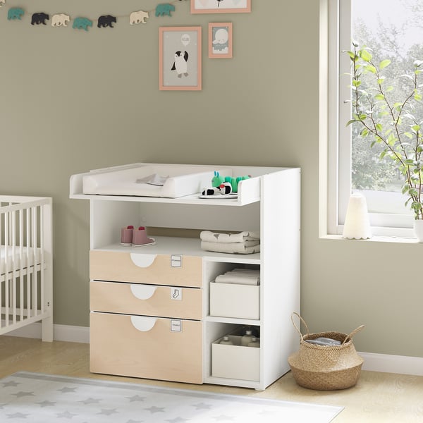 Modern nursery dresser with changing table, light wood and white, three drawers, shelves, and changing pad.