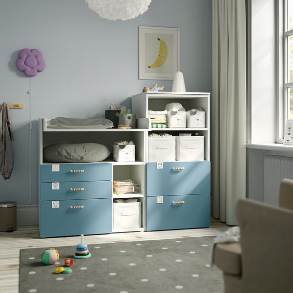 SMÅSTAD blue storage unit with shelves, larger than surrounding toys, holds white bins, cloths, books.