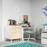 Childrens room with white SMÅSTAD desk, light blue chair, wooden drawers. Laptop, books, colorful decor.