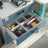 Open blue chest of drawers, organizing small items. Compartments hold toys, office supplies, and accessories. Designed for easy child access.